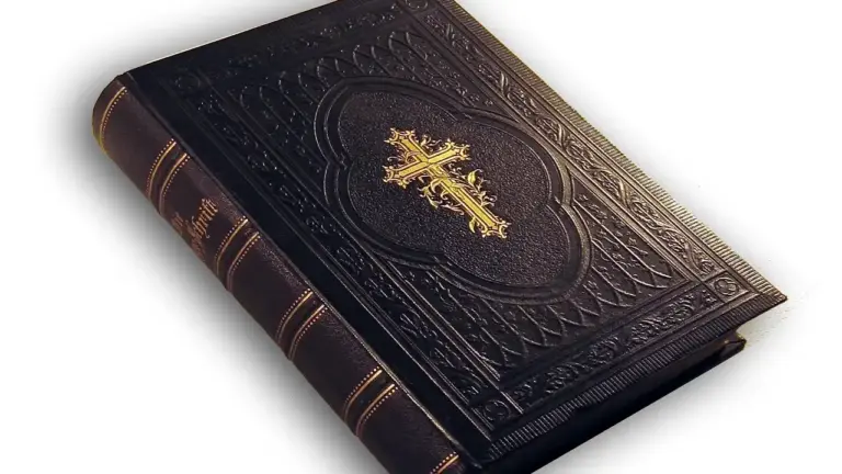 Close-up of a dark leather-bound Bible with an embossed gold cross on the cover