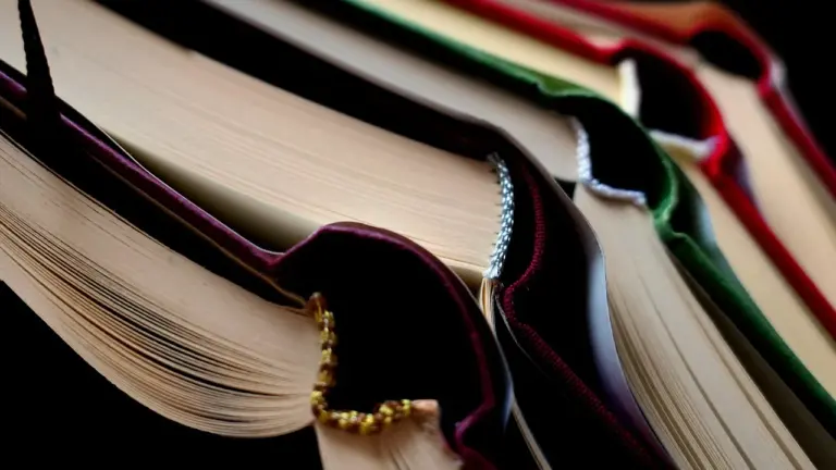 Close-up of a stack of open books with colorful covers and fanned pages