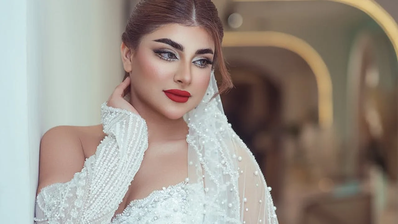 Bride in a white wedding dress and veil, looking over her shoulder with bold makeup.