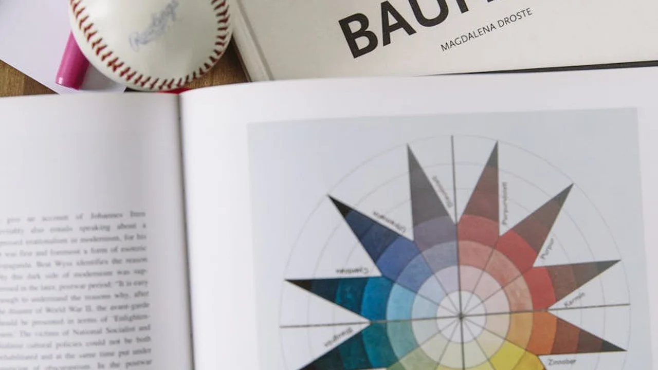 Open art book displaying a circular color wheel with segmented colors, illustrating color theory for developing a personal style in comics, manga, and animation.