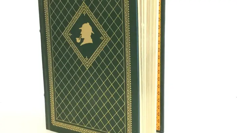 Close-up of a green vintage hardcover book with a gold lattice pattern and a diamond-framed silhouette on the cover.