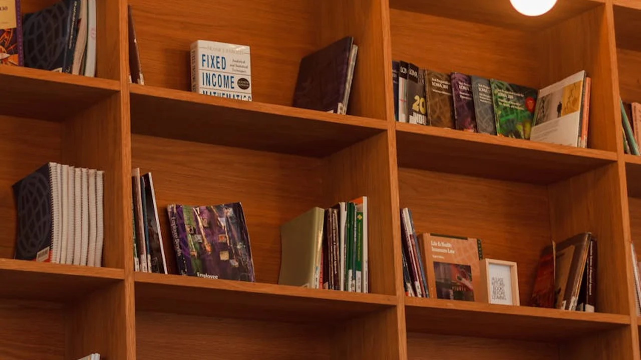 A warm-toned wooden bookshelf filled with neatly arranged fantasy and mystery books.