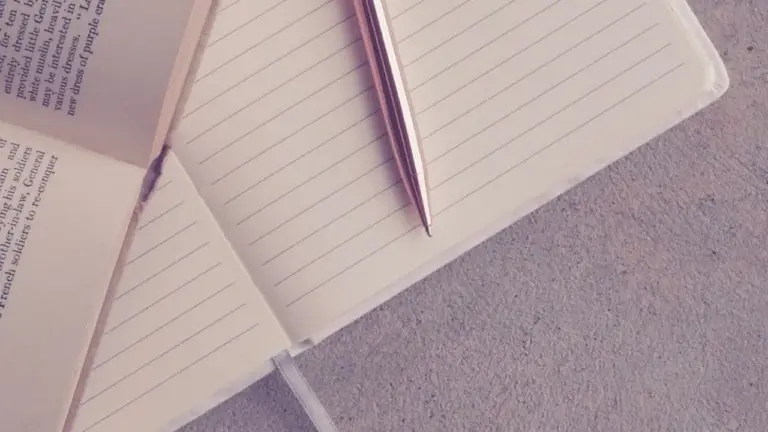 Open notebooks with lined pages and a pencil on a textured surface, symbolizing reflection on parent-child bonds in children's literature.