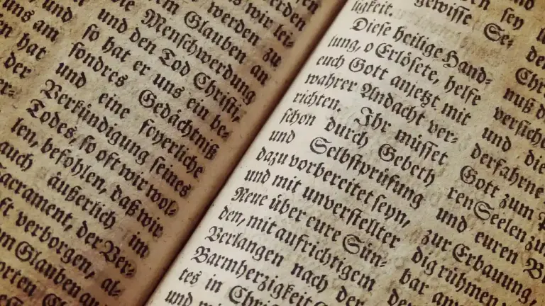 Close-up of aged book pages with dense blackletter text, evoking censorship and control of knowledge.