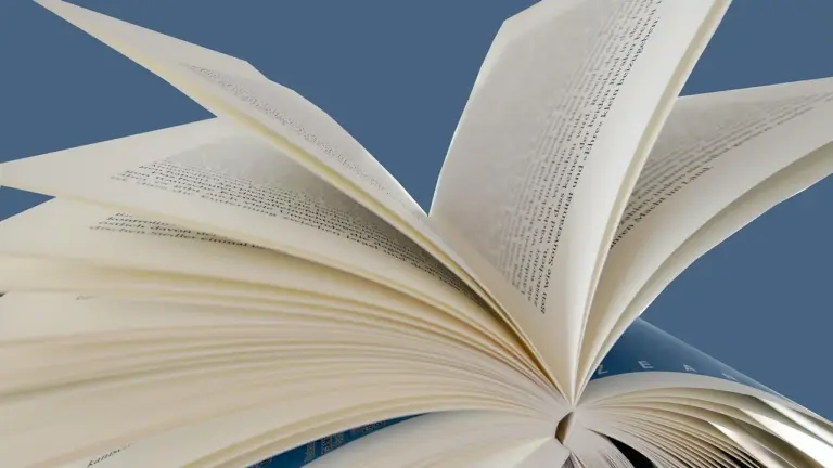 Open book pages fanned out against a blue background.
