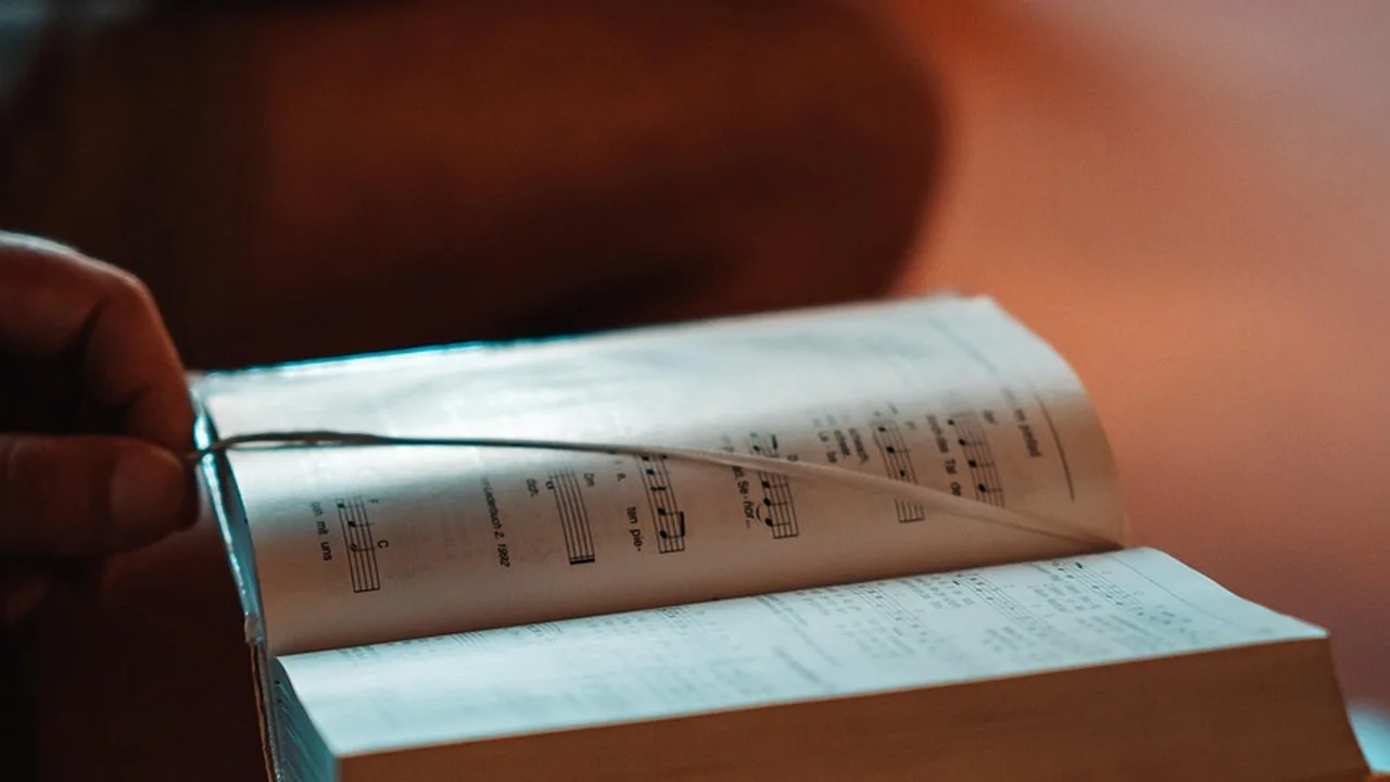 Close-up of an open book with pages of sheet music, bathed in warm light.