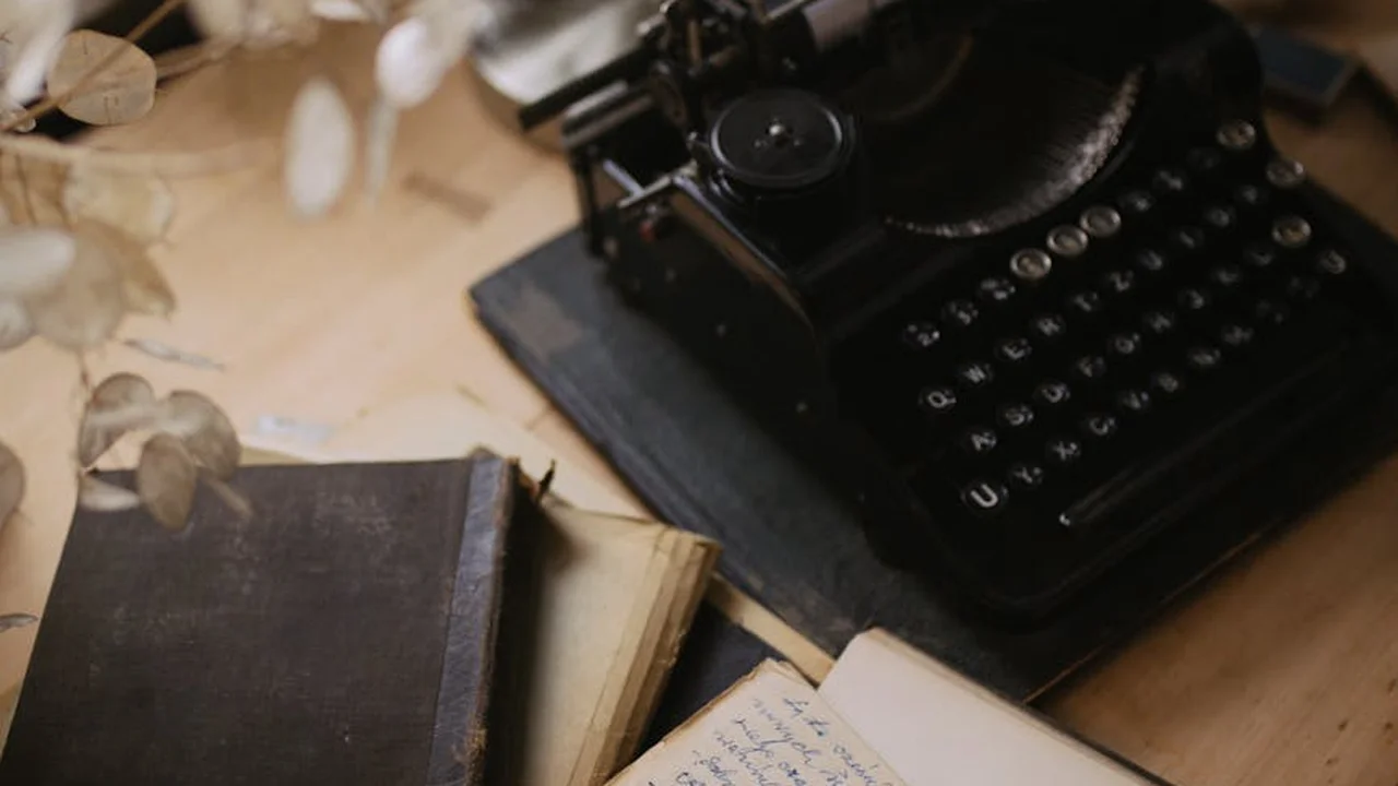 Vintage black typewriter on a wooden desk beside weathered notebooks and dried leaves, evoking a nostalgic post-apocalyptic reading mood.